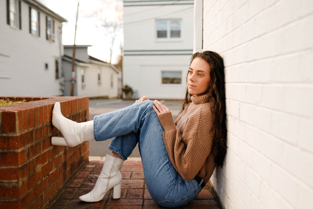 Senior session in the winter with chunky sweater and cute boots on main street in Madison, Virginia.