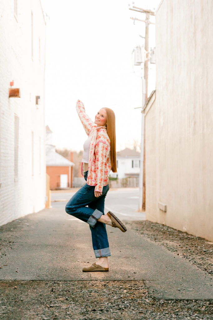 High school junior posing in a charming small town during golden hour for a Class of 2027 senior photo session.